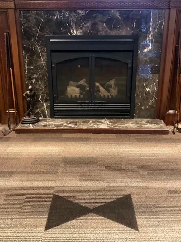Marble fireplace with the Black Tie bow tie crest in the carpet